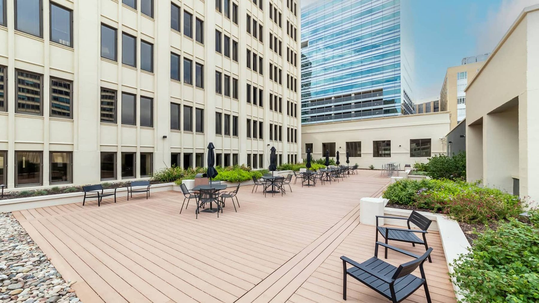 The building's shared rooftop terrace with deck seating and planters